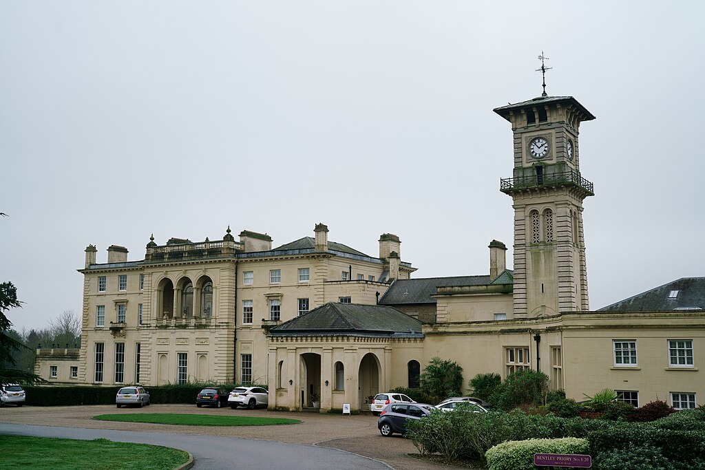 Elegant historical building with a prominent clock tower and parked cars in front. | Bentley Priory by Peter Trimming, CC BY-SA 2.0, via Wikimedia Commons