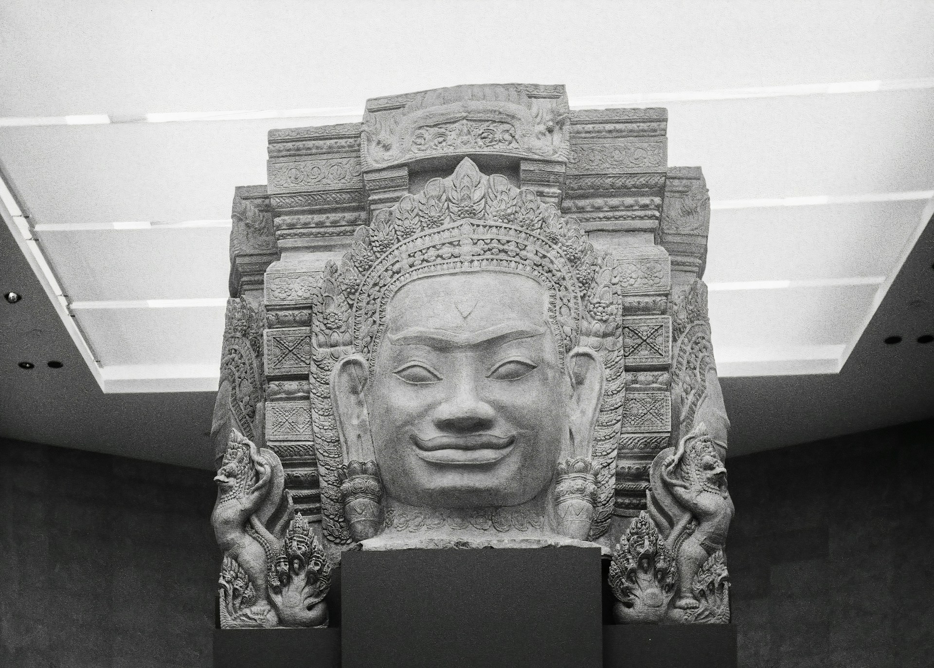 Stone statue in an art gallery of a wide smiling face | Photo by Lizgrin F on Unsplash