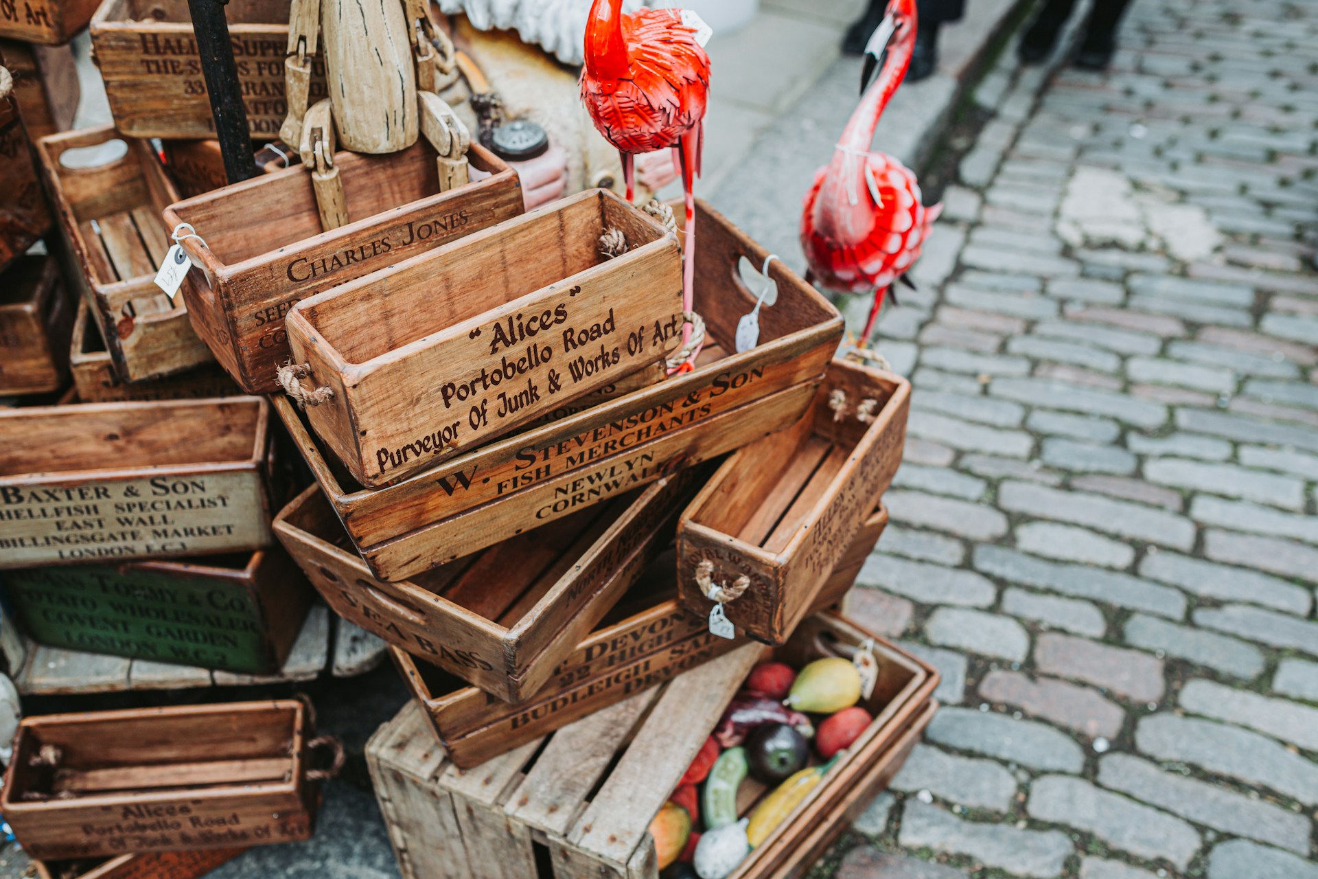 Assortment of rustic wooden crates with signage, on a cobblestone street. | Photo by Bruno Martins on Unsplash