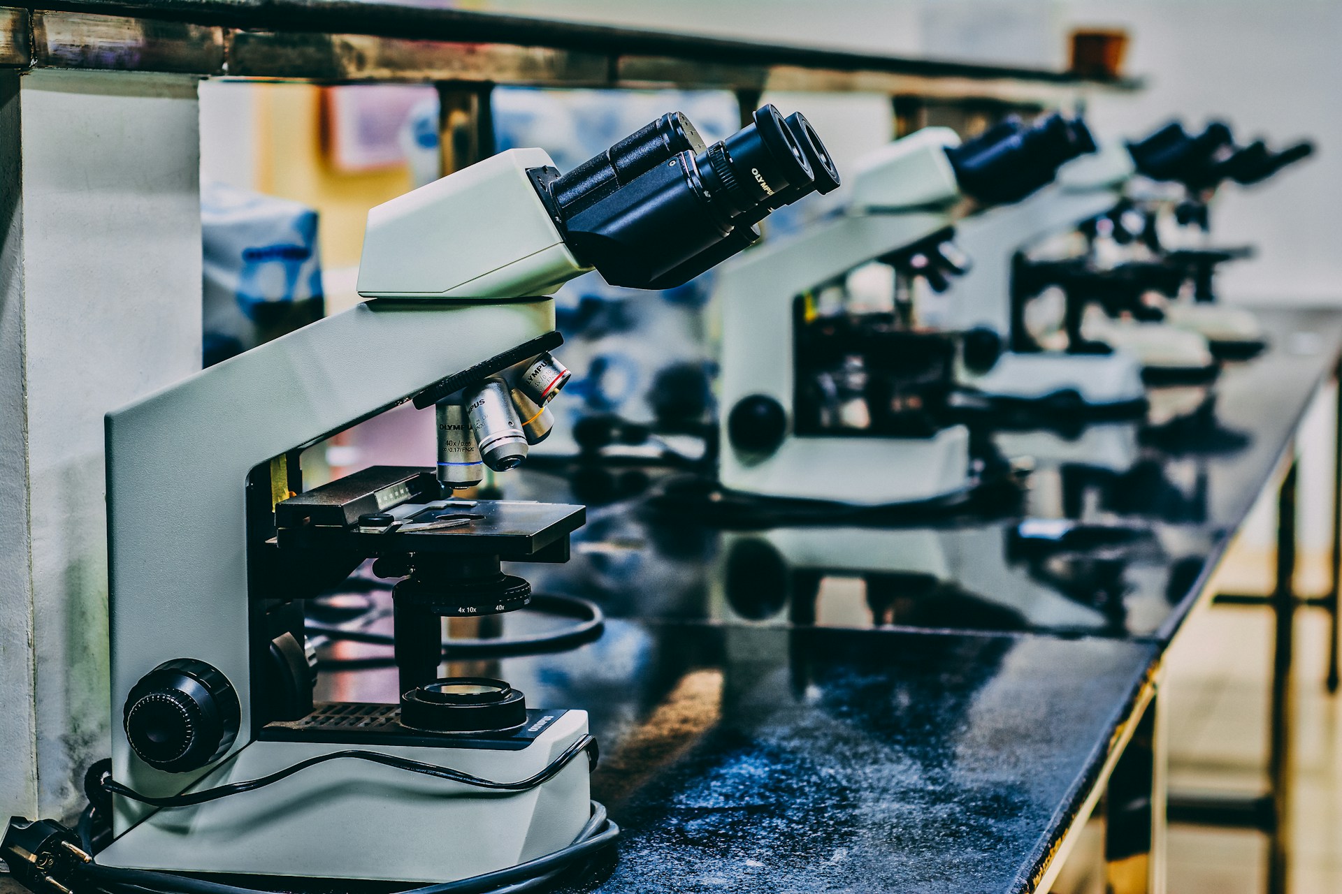 A row of microscopes on a laboratory bench. | Photo by Ousa Chea on Unsplash