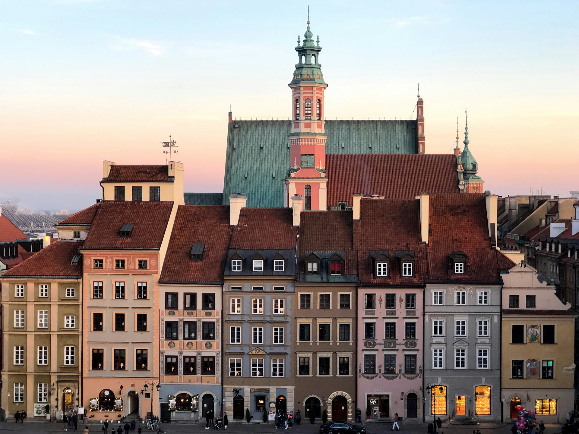 Warsaw's Old Town with historic colorful buildings and the Royal Castle in the background at dusk. | Photo by Maksym Harbar on Unsplash
