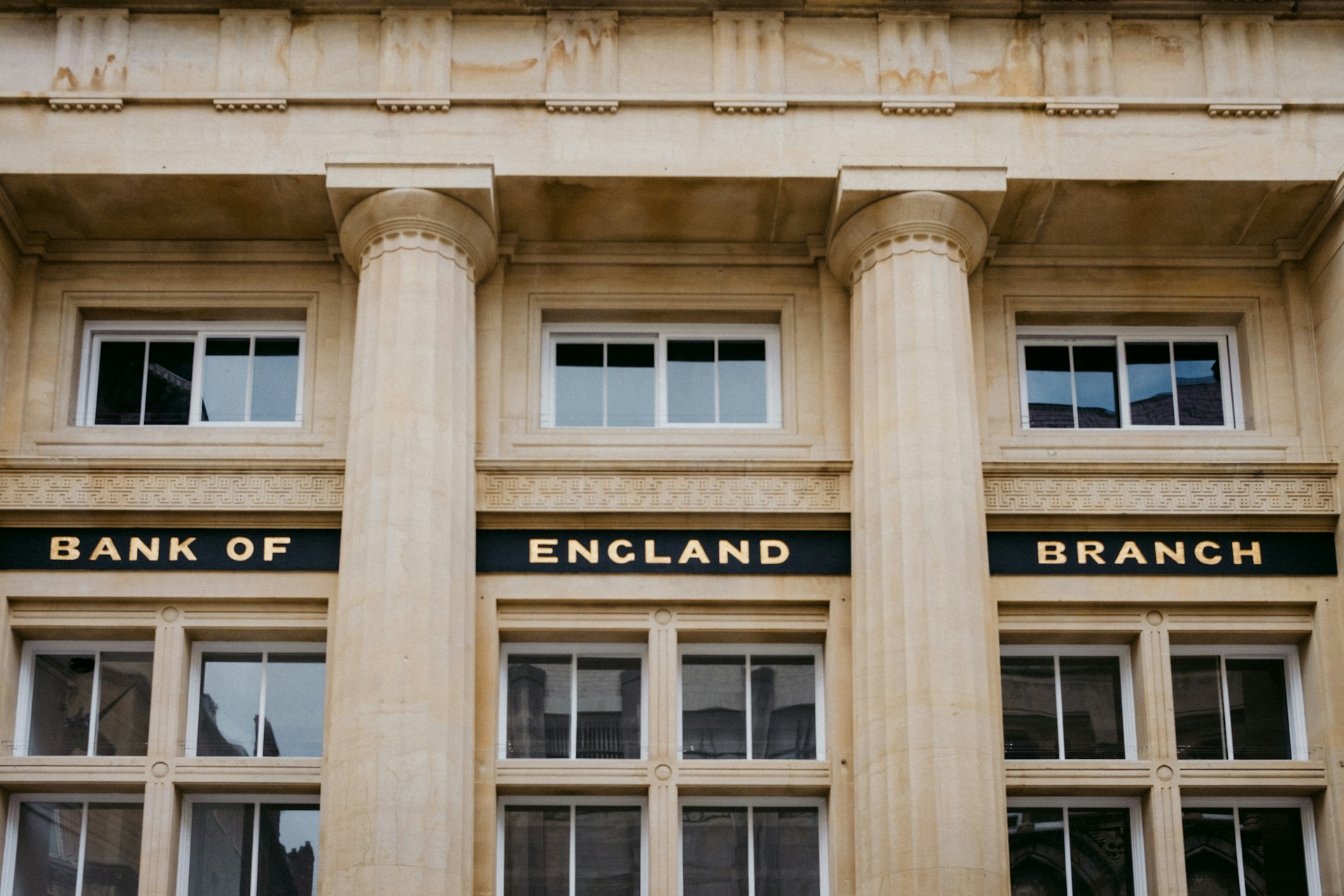 Facade of a building with columns labeled "Bank of England Branch". | Photo by Annie Spratt on Unsplash