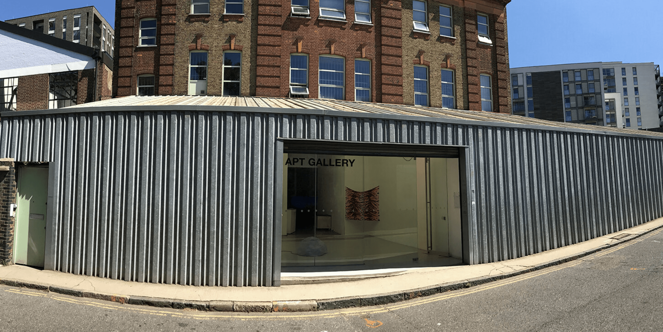 Exterior of APT Gallery with corrugated metal facade on a sunny day. | Art in Perpetuity Trust 2020