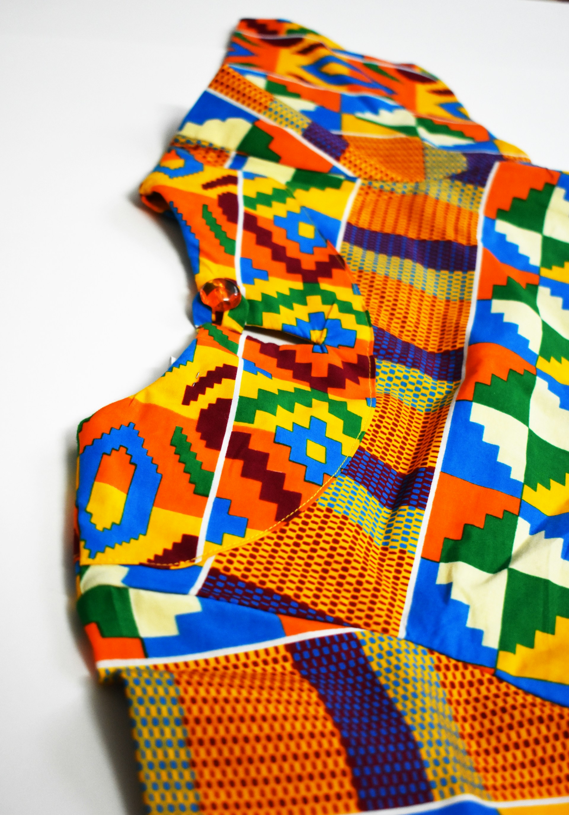 Colorful patterned shirt with a button detail on a white background. | Photo by Delight Dzansi on Unsplash