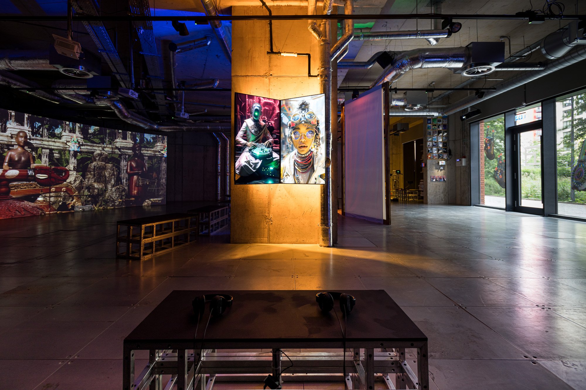 An interior of a gallery with projected and mounted artworks, and modern industrial design elements. | Murthovic & Thiruda, Fragments of a Panorama, 2024. Installation view, arebyte Gallery, London. Image: Devika Bilimoria.