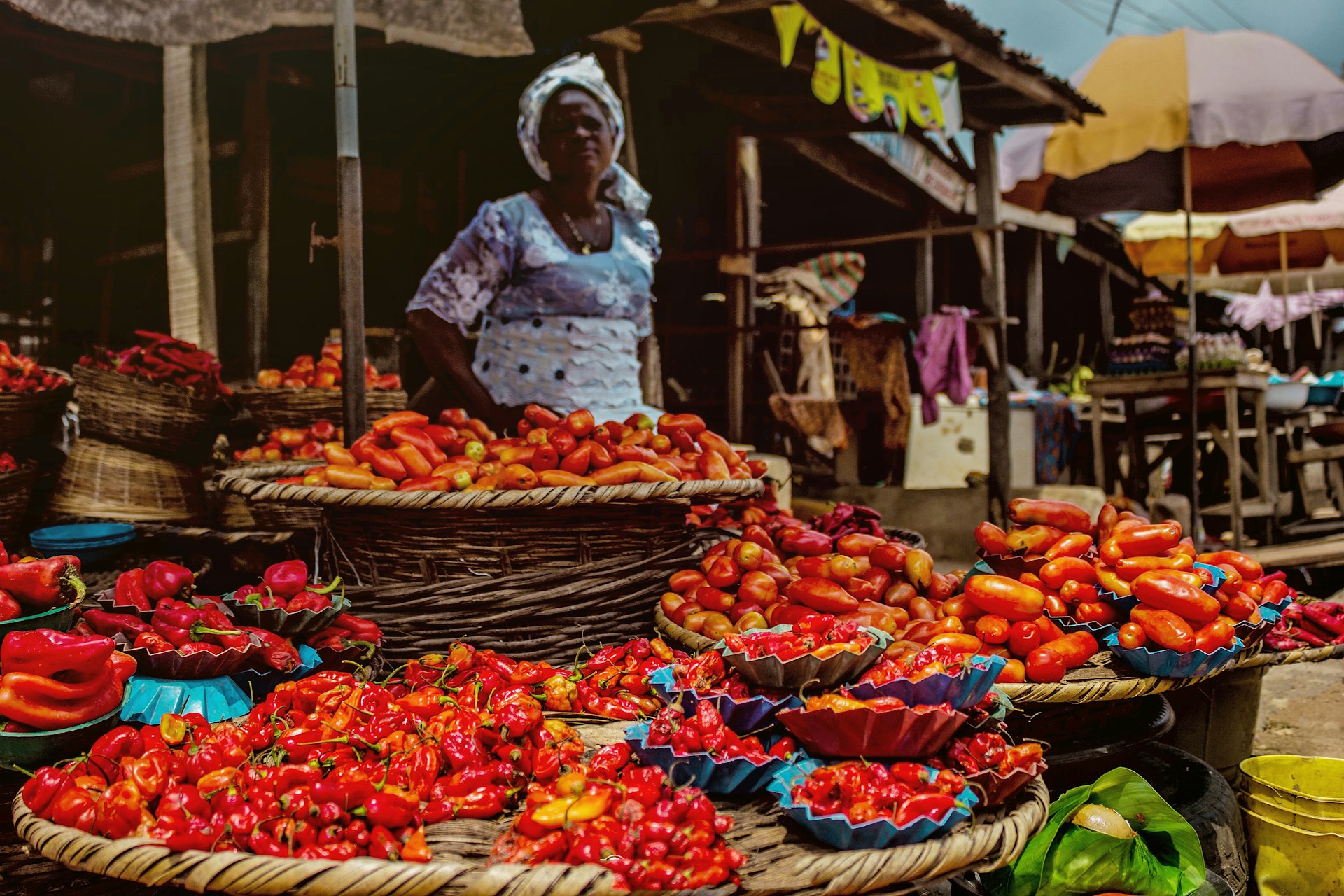 A vibrant market scene with baskets of fresh red and yellow peppers on display. | Photo by Omotayo Tajudeen on Unsplash