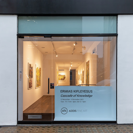 Front view of an art gallery entrance displaying exhibition posters and interior artwork. | Addis Fine Art