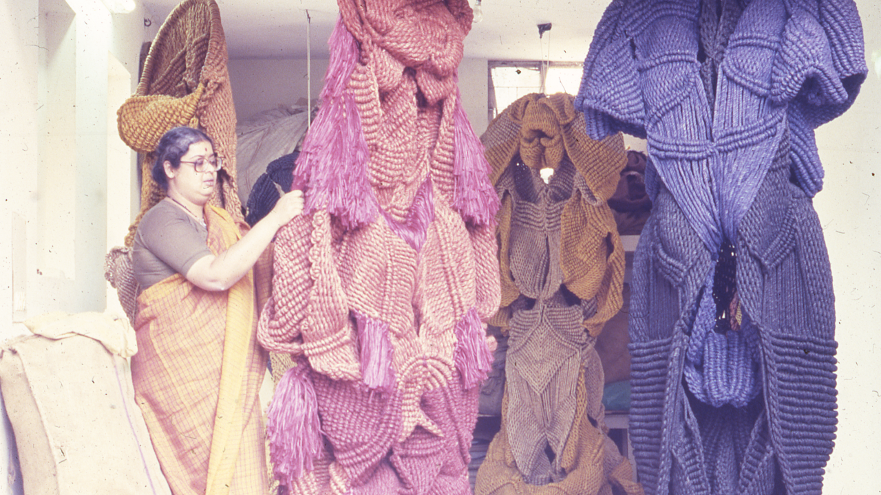 Large colorful knitted sculptures displayed in an indoor setting.