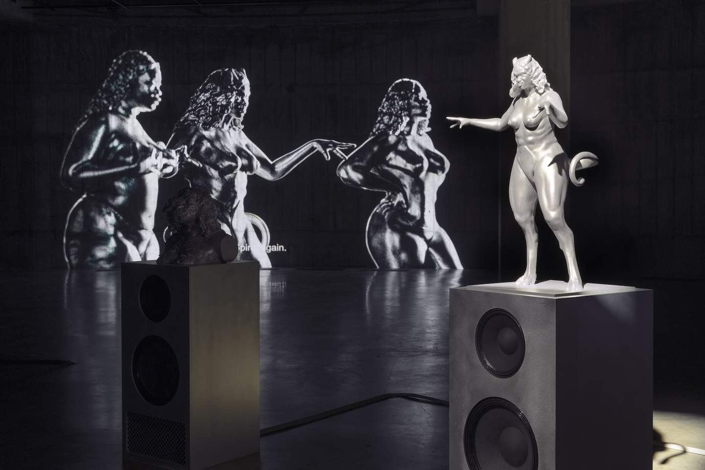 Sculptures and projections in a dimly lit space.