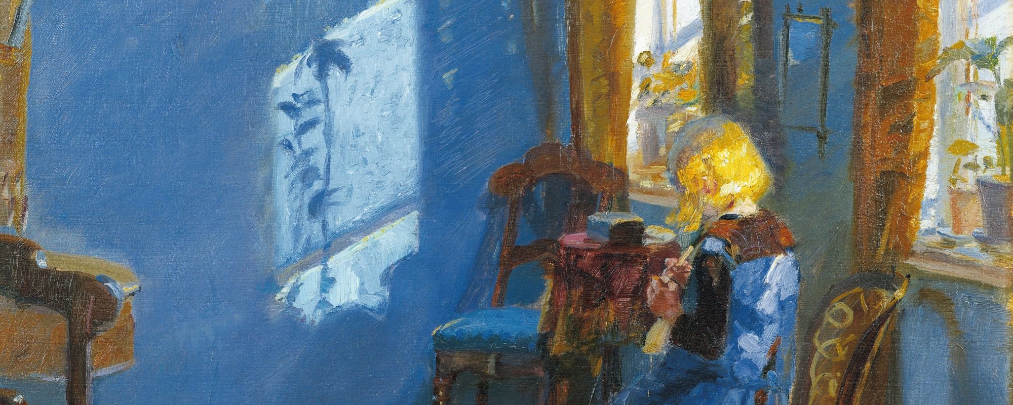 A girl with blonde hair sits at a table in a sunlit room, surrounded by blue walls and plants, focused on her work.