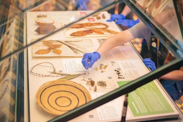 A person wearing gloves is writing on a piece of paper placed on a table.