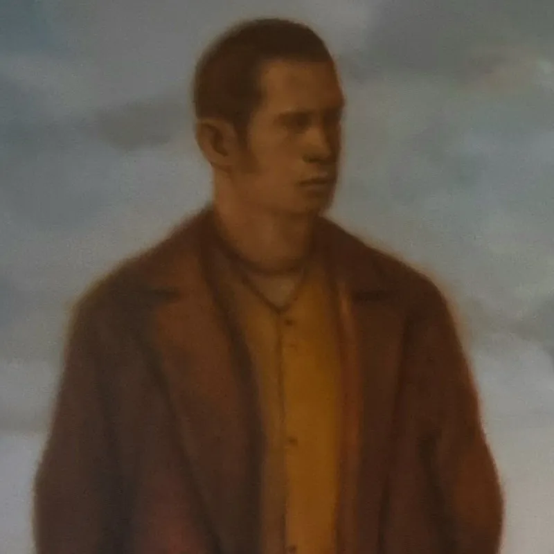 A man wearing a brown coat is posing for the portrait.