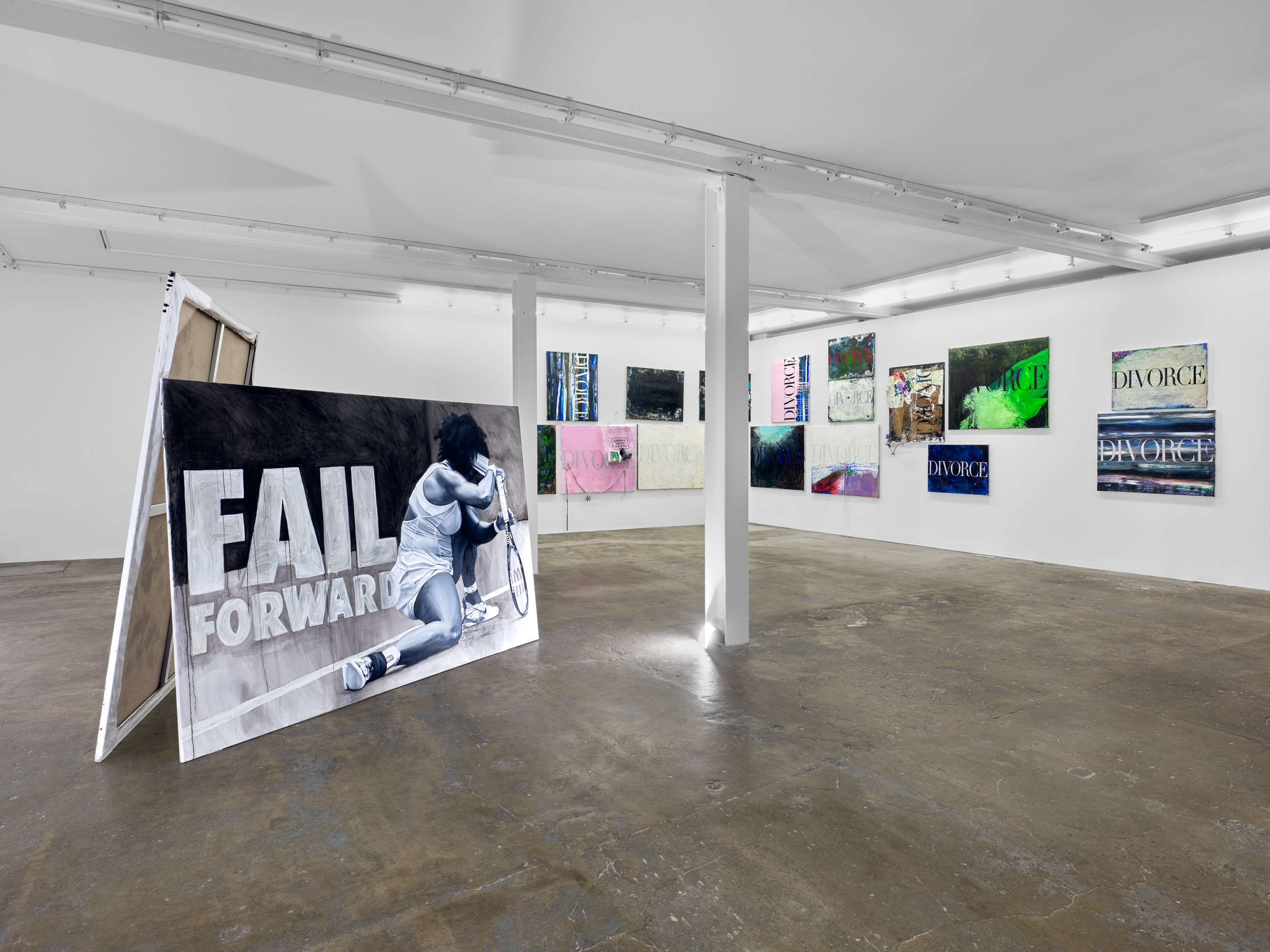 A room featuring various artworks displayed on the walls, with a focus on paintings. The space is designed as an art gallery, and the ceiling adds to the indoor ambiance. The floor complements the overall exhibition layout.