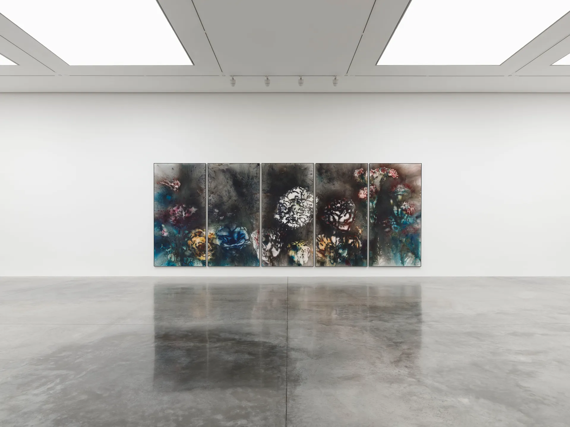 A room featuring various pieces of art displayed on the walls, highlighting modern and visual arts in an exhibition setting.