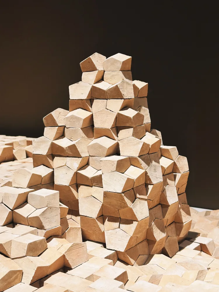 A stack of wooden blocks arranged in a neat pile.