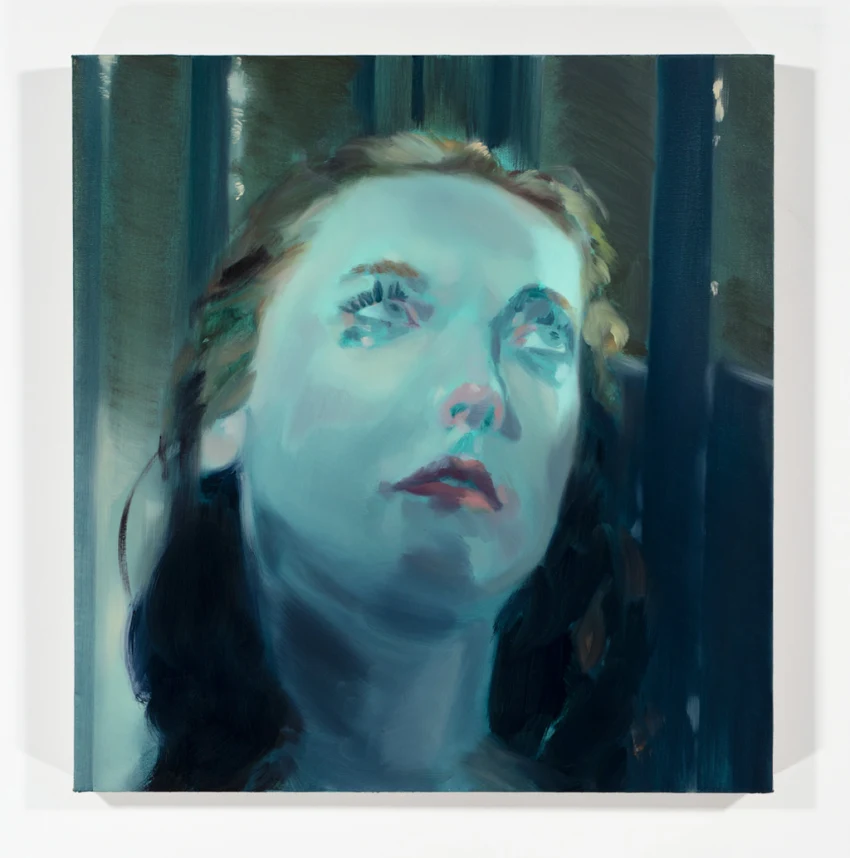 A woman gazes upward with a thoughtful expression, her features illuminated softly. Her lips are slightly parted and her eyebrows are gently raised, conveying curiosity or wonder. The focus is on her face, which shows detail in her skin texture and hair.