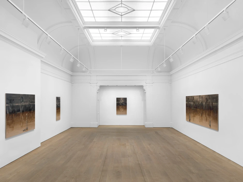 A room displaying various paintings on the walls, featuring an art gallery atmosphere with a polished floor and framed artworks. The ceiling adds to the aesthetic of the indoor space.