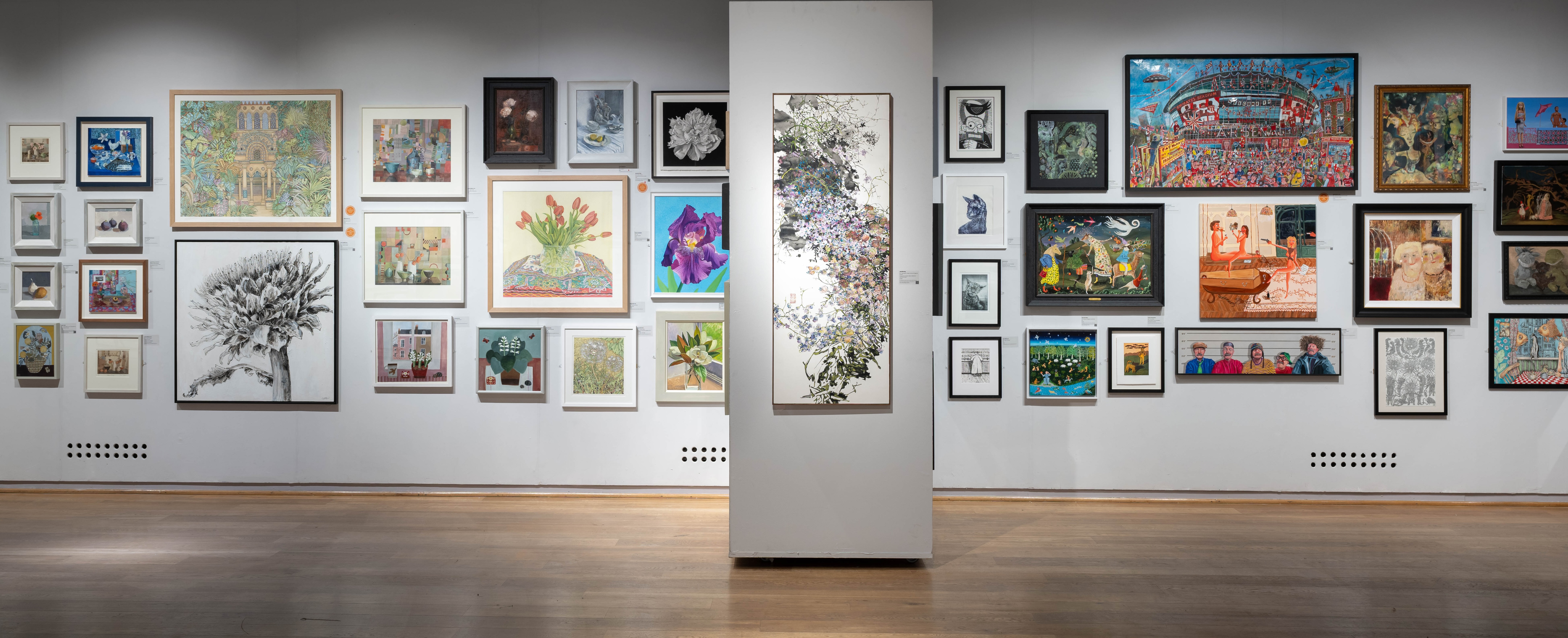 An art gallery wall showcasing a diverse array of framed artworks, including paintings and drawings in various styles and colors.