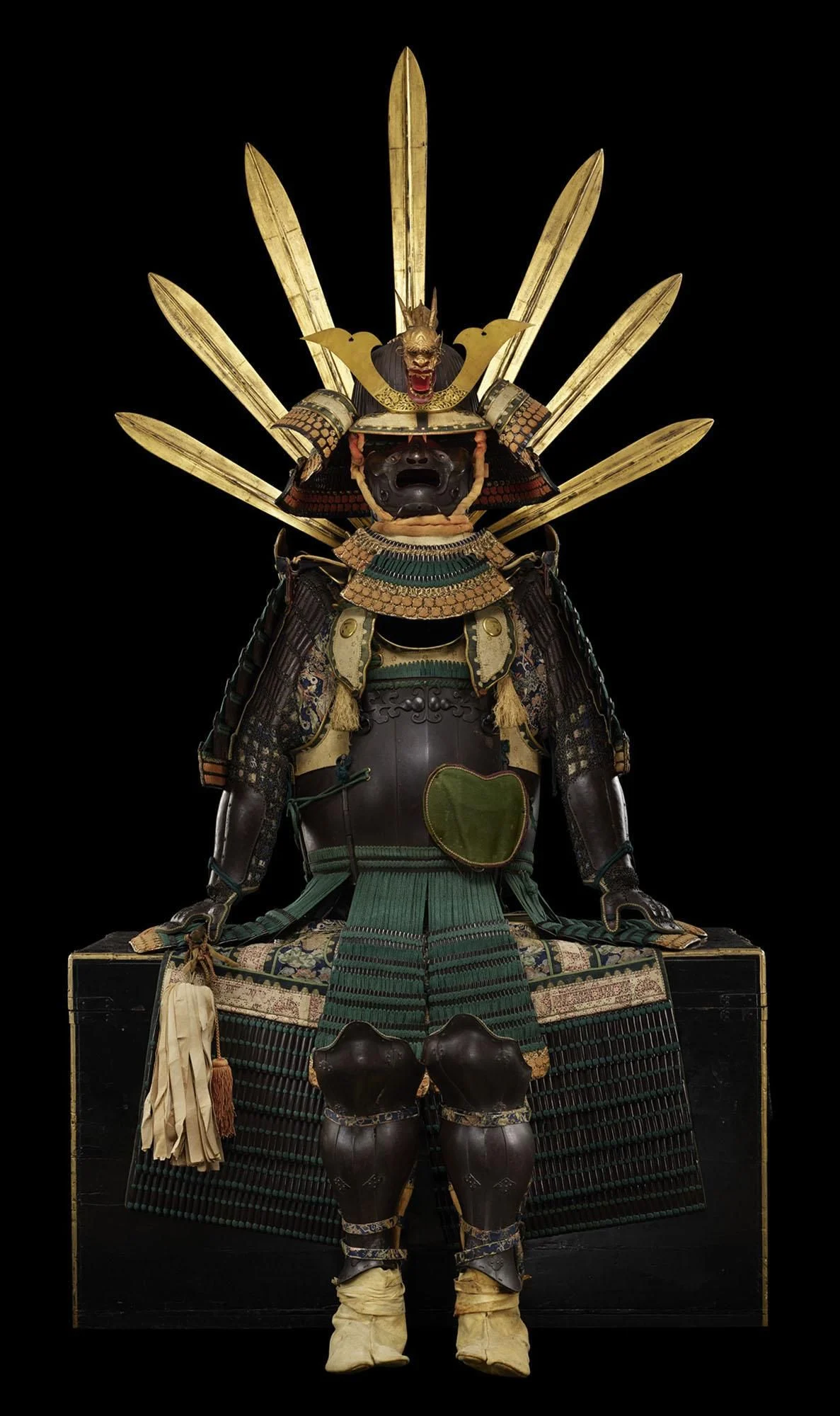 A detailed statue of a samurai in traditional armor, showcasing intricate designs and features typical of the warrior's attire. The figure is depicted in a dynamic pose, emphasizing its craftsmanship as a collectible toy or action figure.
