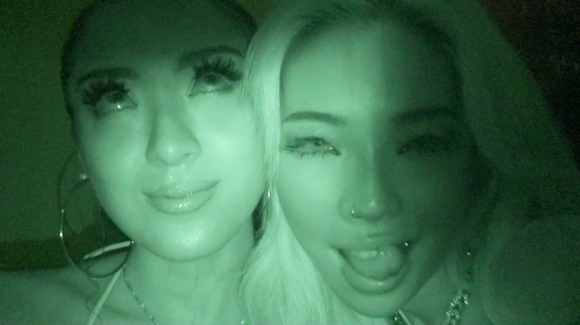 Two women smiling and taking a selfie indoors.