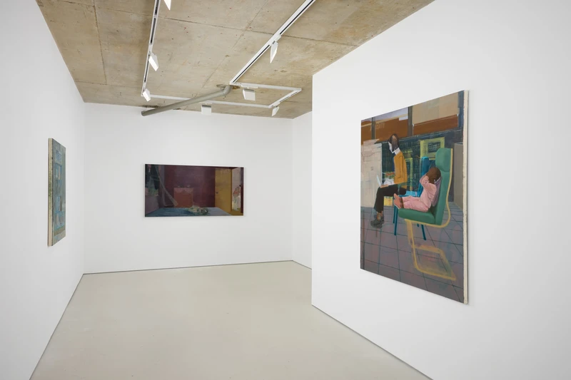 A room featuring several paintings displayed on the walls, showcasing various art styles in an art gallery setting.