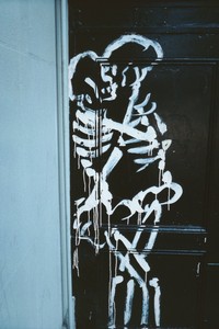 A wall featuring a painted skeleton, displayed as street art or graffiti.