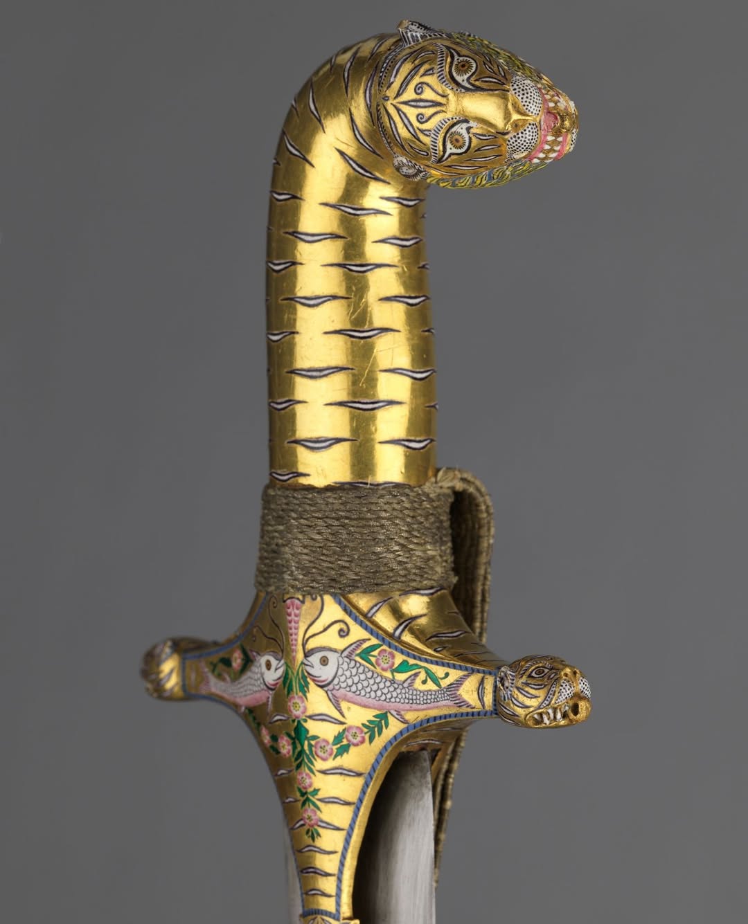 A gold sword featuring an ornate handle, displaying intricate details and craftsmanship.