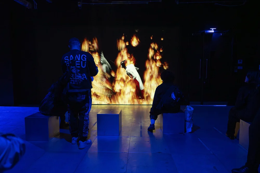 Alt text: A group of people standing in front of a large screen, engaged in dance and entertainment activities indoors.