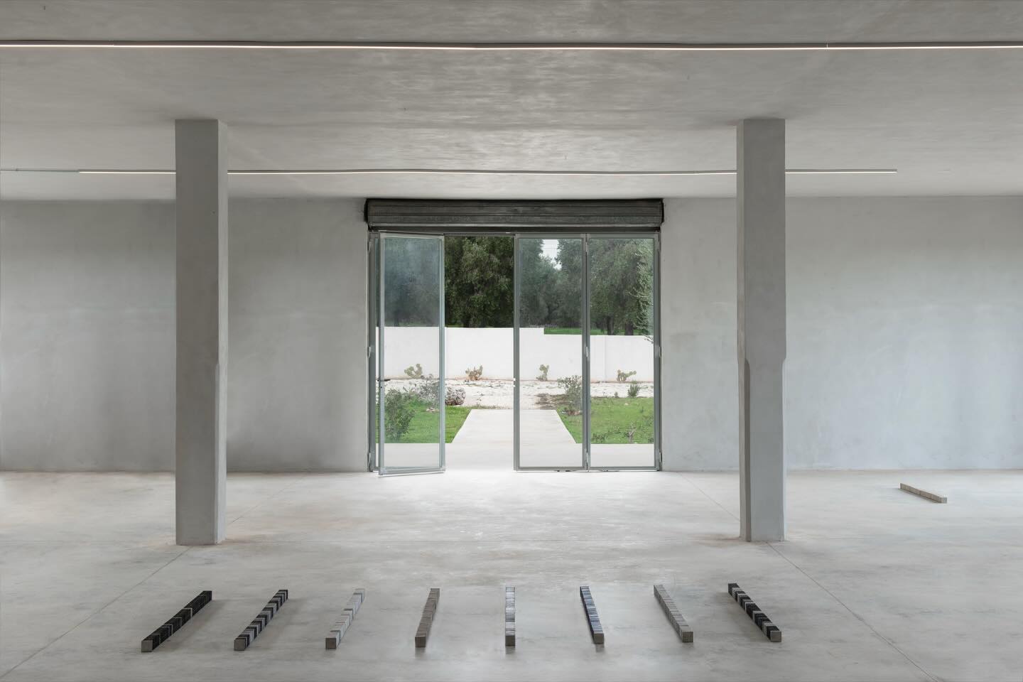 A spacious room featuring a large glass door, with stylish flooring and modern interior design elements.