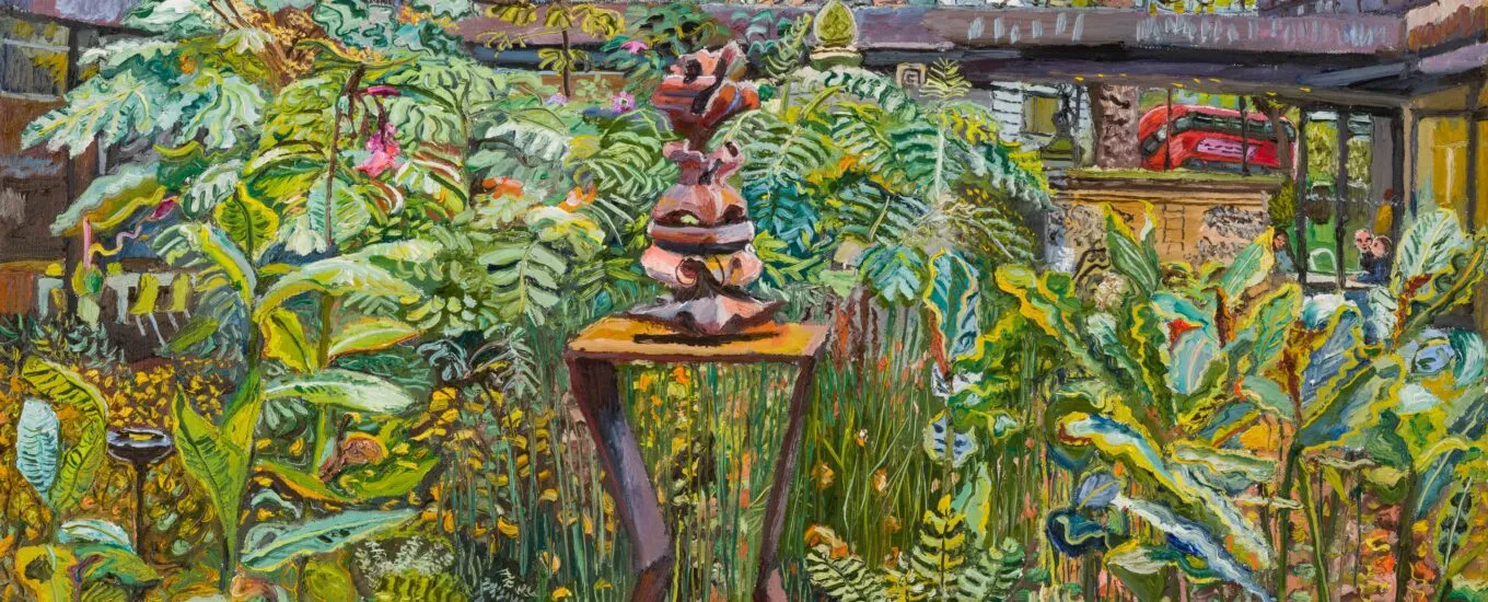 A sculpture displayed in a lush garden surrounded by various plants.