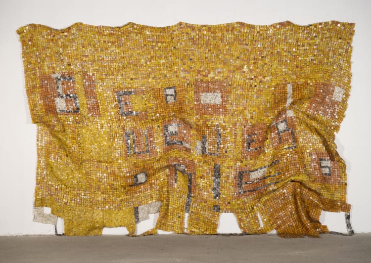 Textured mosaic art piece with a warm yellow and orange palette, displaying abstract shapes and graphic elements.