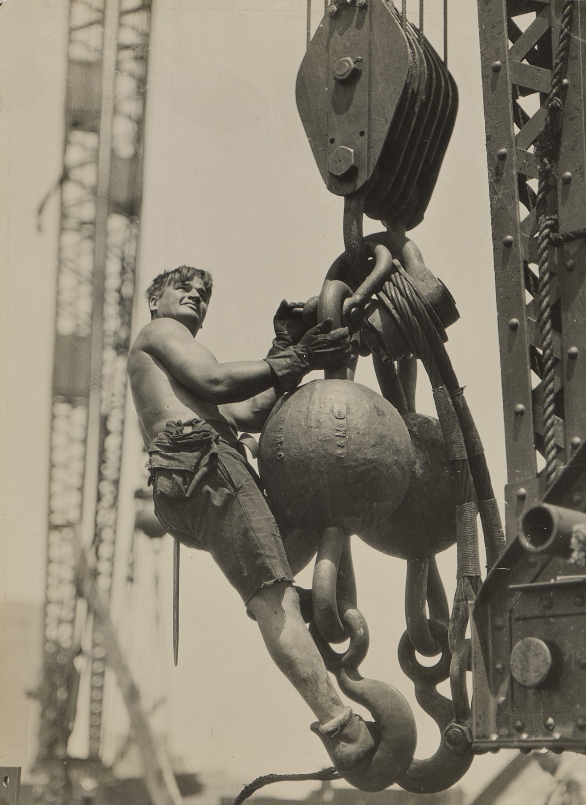 A man is climbing a large metallic sculpture outdoors, captured in black and white. | 2026 Dulwich Picture Gallery