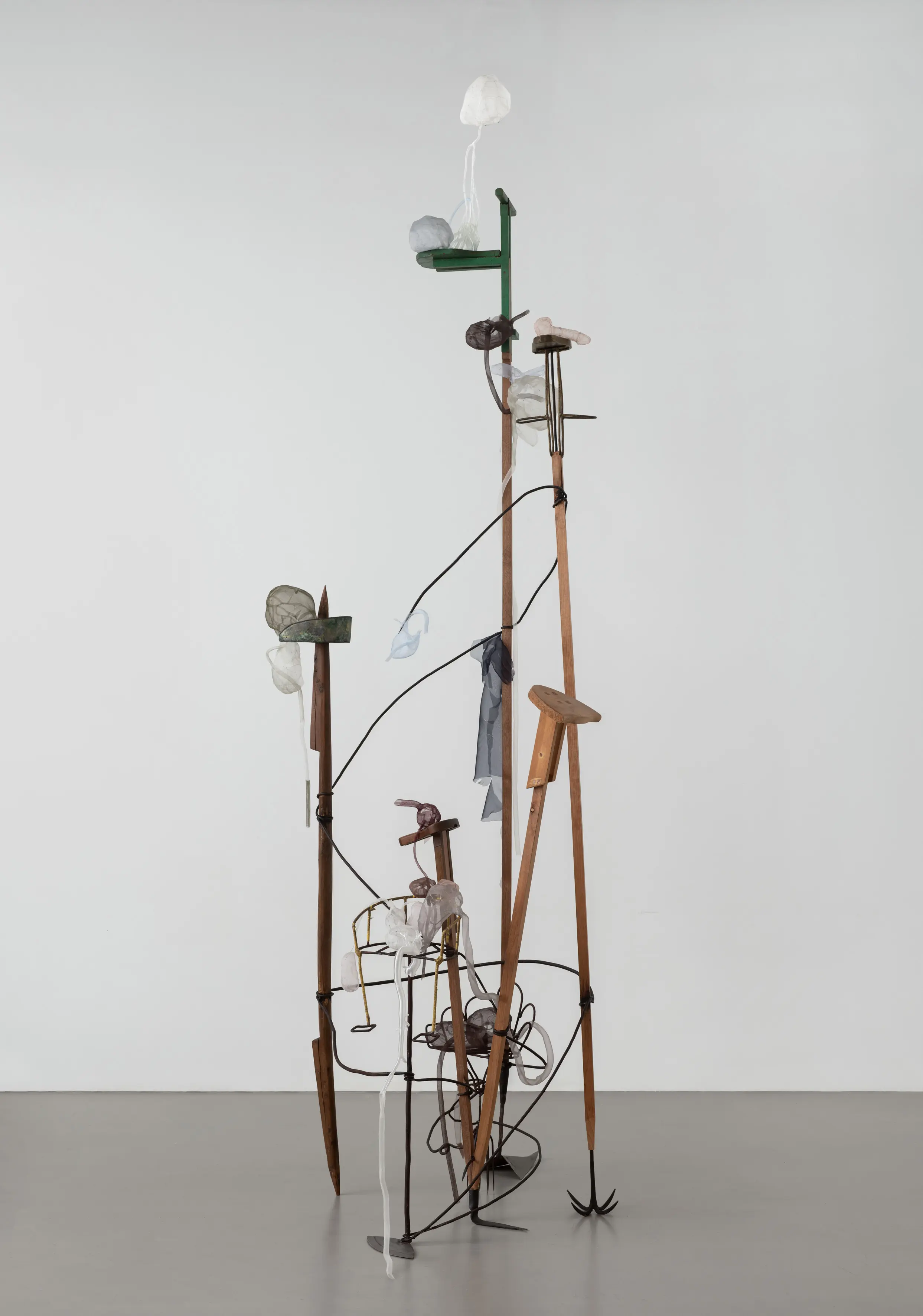 A collection of objects displayed on a stand, set against a wall in an indoor environment, captured with a tripod.