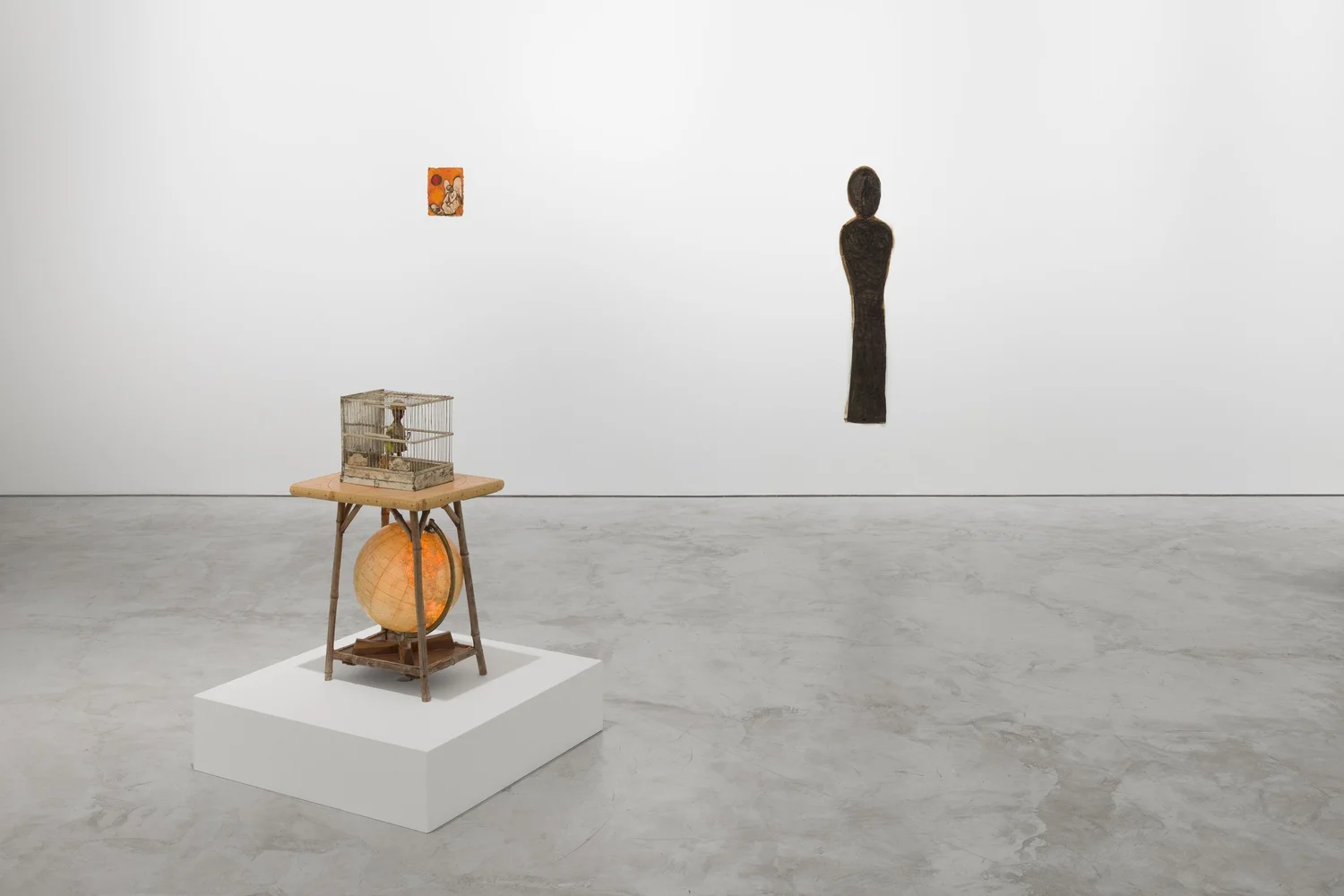 A sculpture mounted on a wall in an indoor space, surrounded by flooring and furniture, resembling art typically found in a museum.