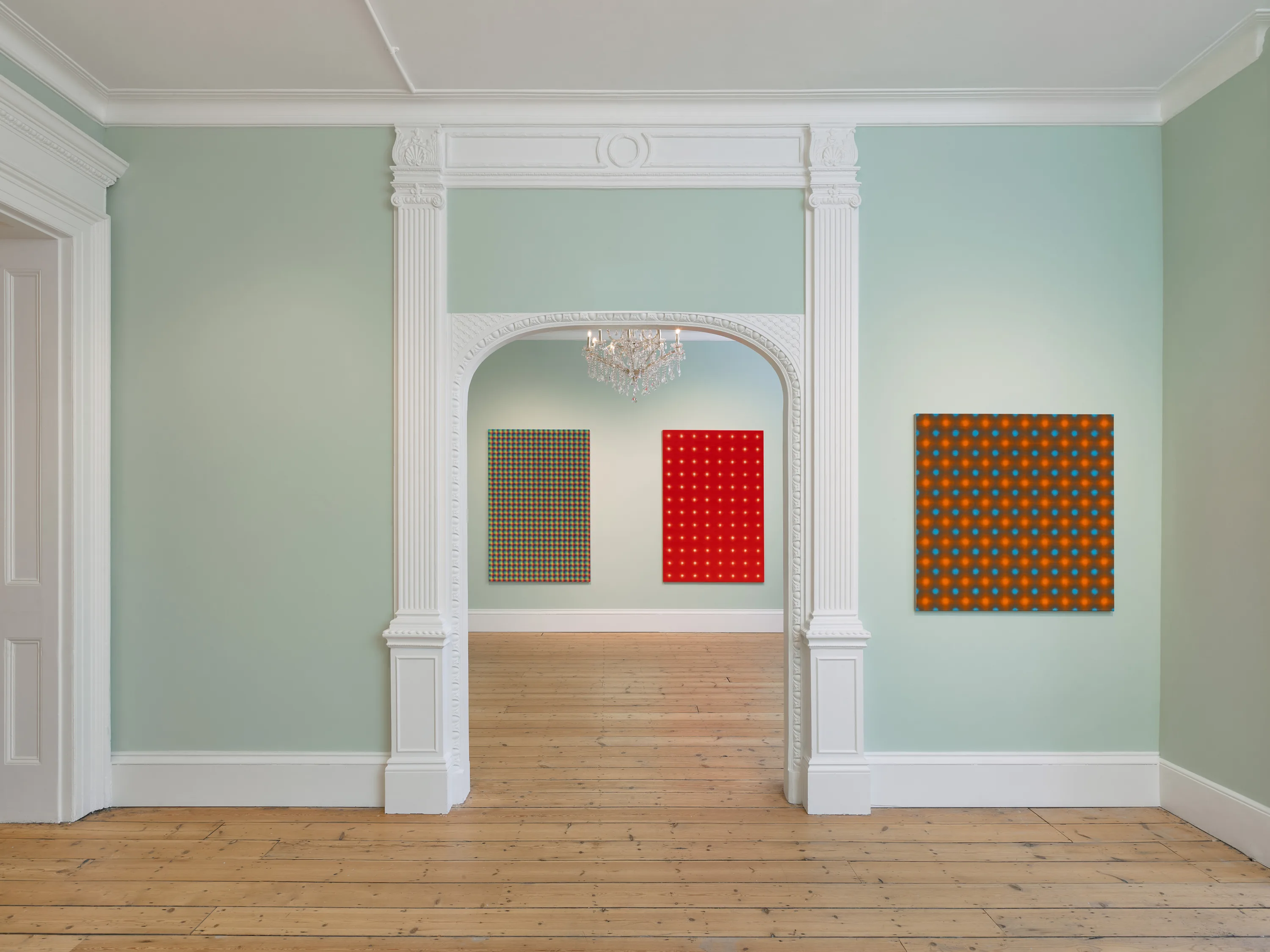 A room featuring a white doorway and door, complemented by a wood floor.