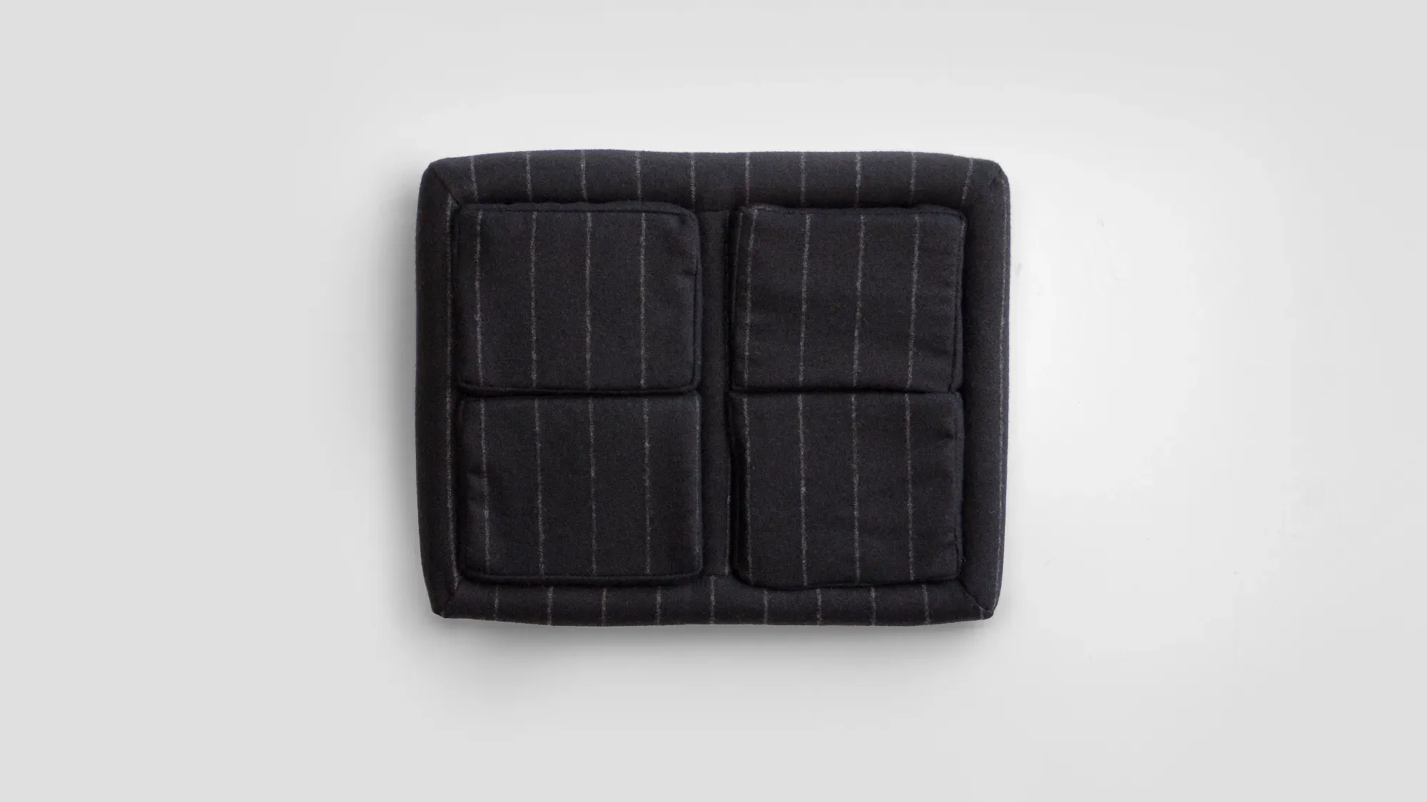 A black rectangular cushion with striped patterns, featuring two square sections.