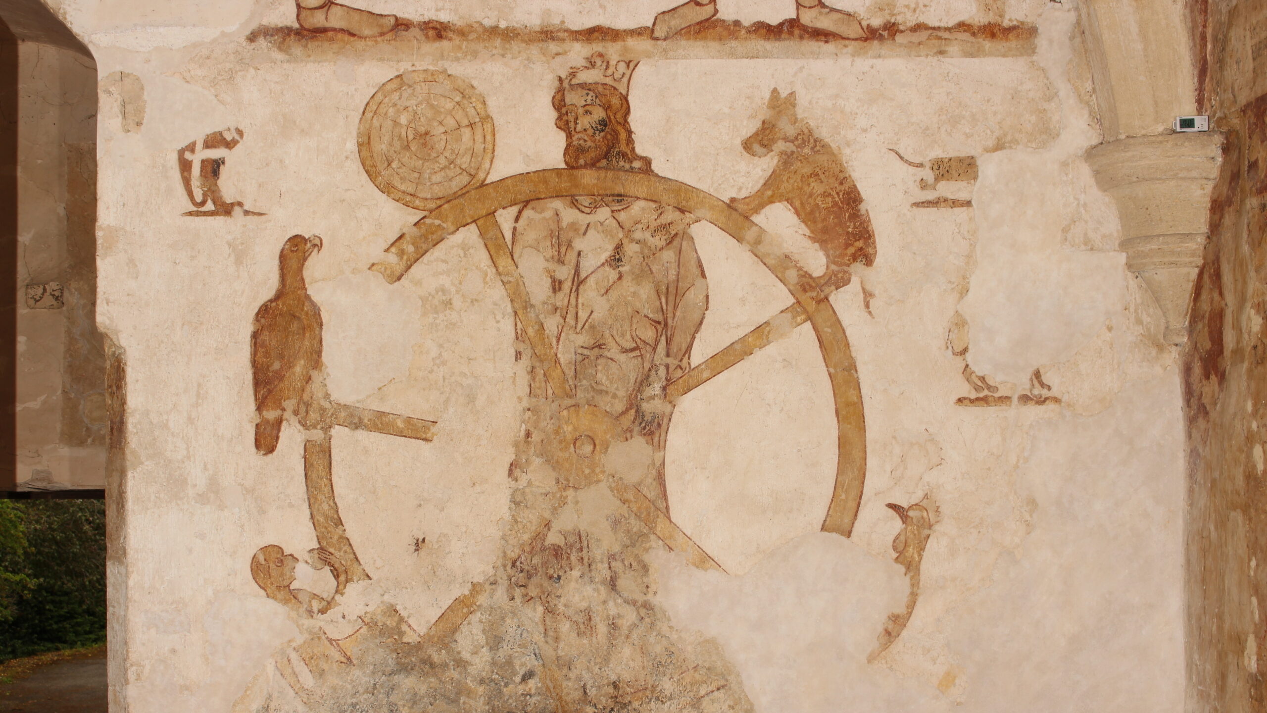 A faded mural depicting a figure seated on a wheel, surrounded by various animals including a bird and two other creatures, with symbols and figures surrounding the main subject. | 2026 Courtauld Gallery