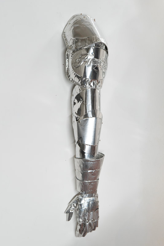 A metallic-looking prosthetic arm made from a shiny, reflective material. | 2026 Copperfield Gallery