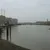 A river or body of water surrounded by buildings and structures, under a cloudy sky.