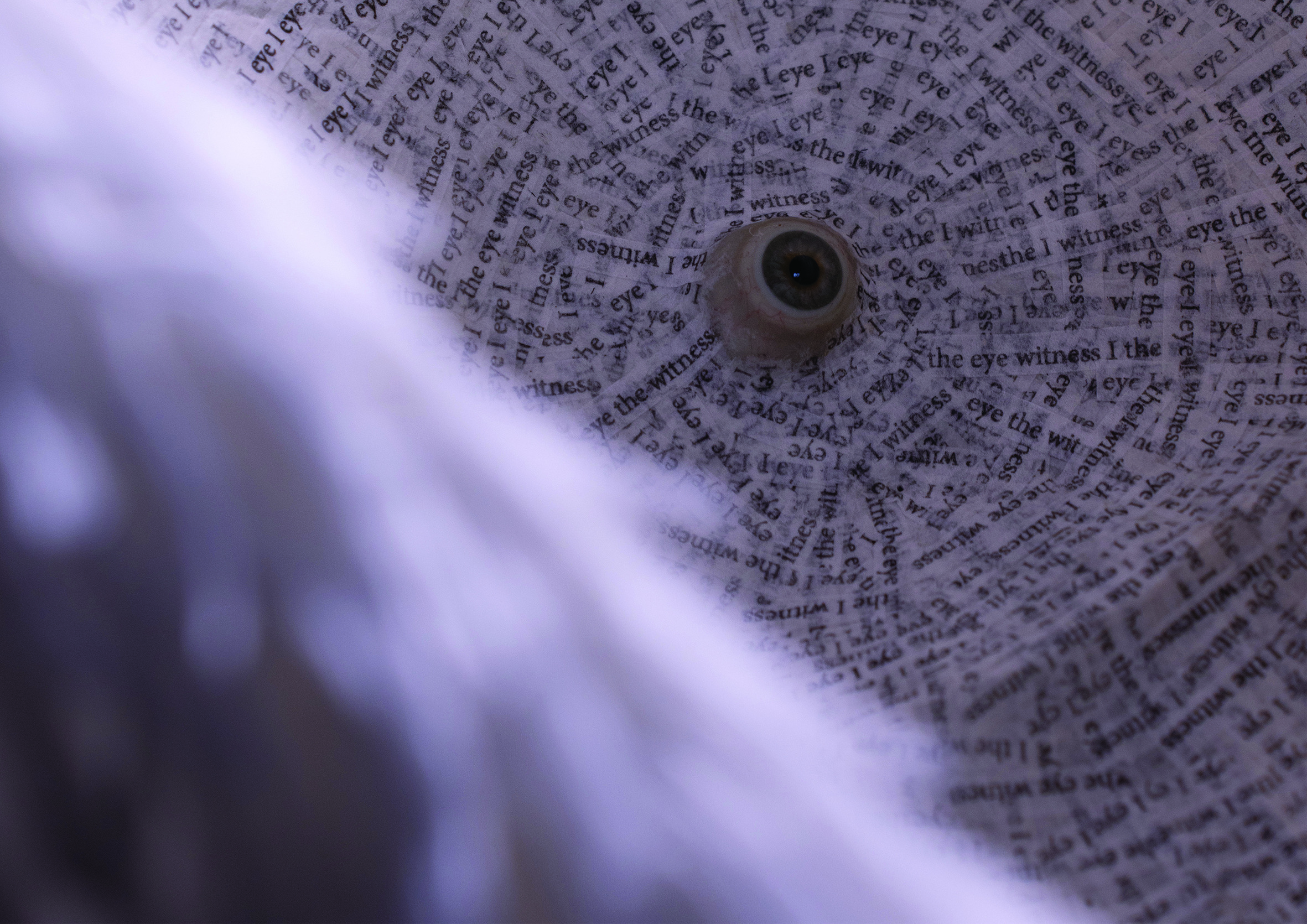 A close-up view of the inside of a lamp with text covering its surface, creating an intricate pattern.