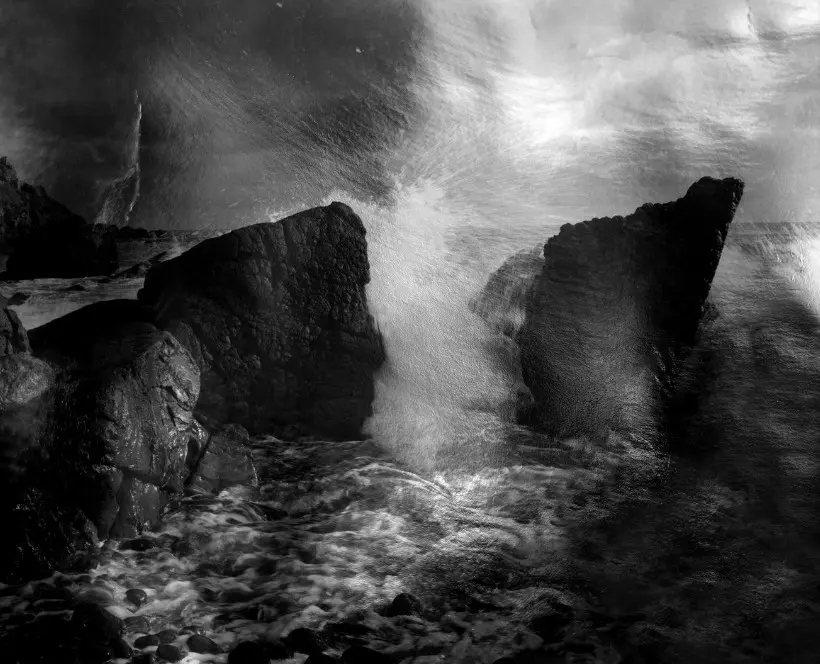 Black and white image of ocean waves crashing against rocky cliffs. | 2026 Photographers