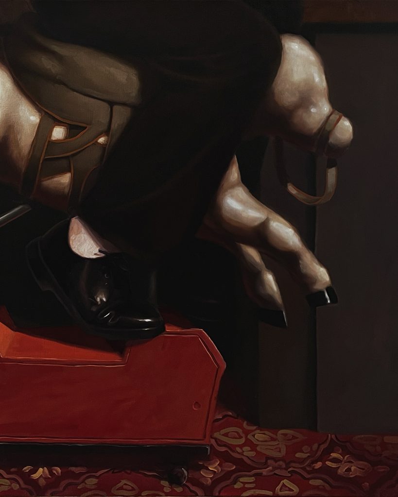 A person's foot in a black shoe rests on an ornate red platform, while their leg is draped over a sculptural element resembling the upper body of a horse. The background features dark tones, creating a dramatic effect.