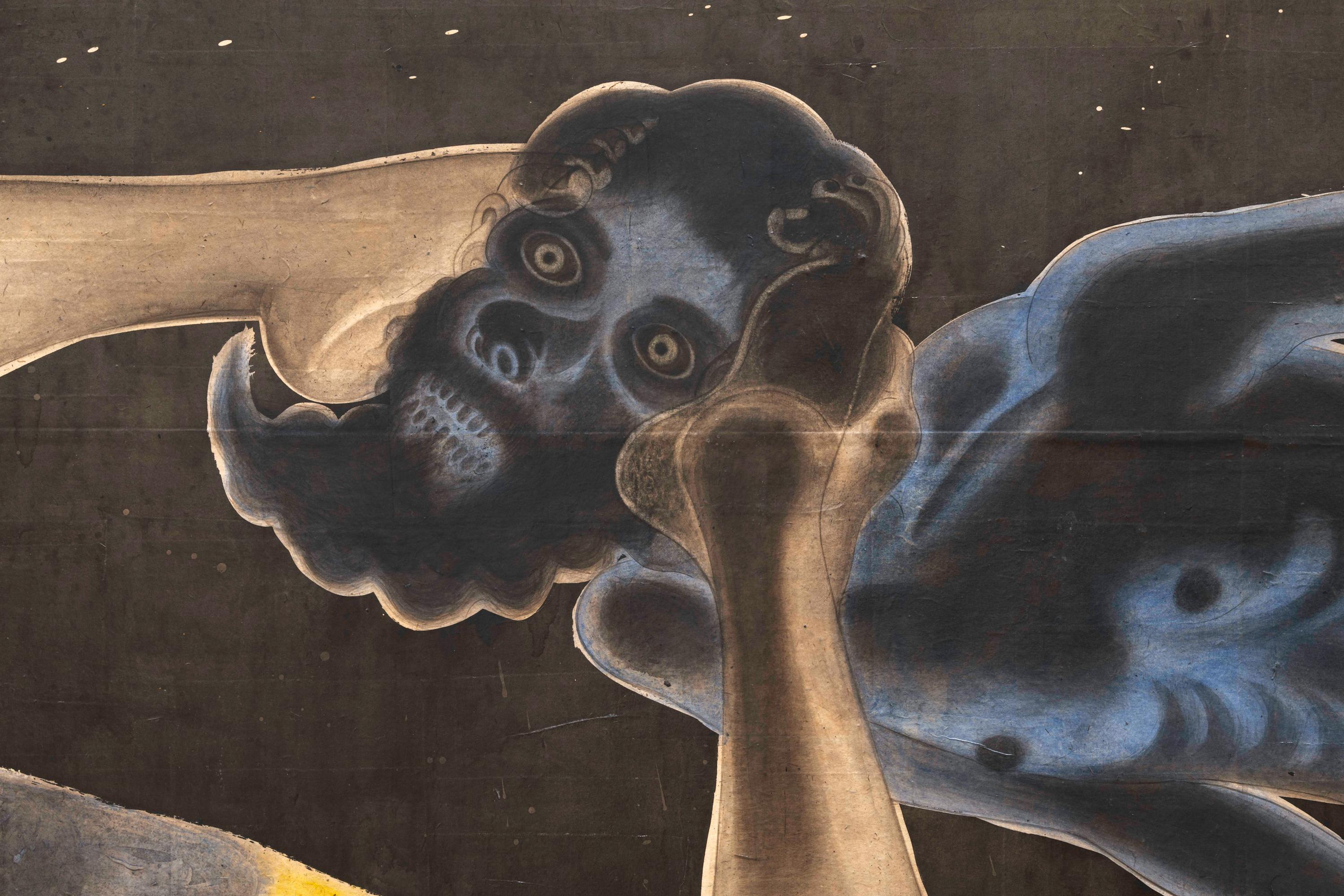 A close-up of a painted figure with a beard and exaggerated facial features, gripping its own head against a dark background. The figure has large, round eyes and an intense expression, with contrasting colors highlighting its form. | 2026 Studio Voltaire Gallery