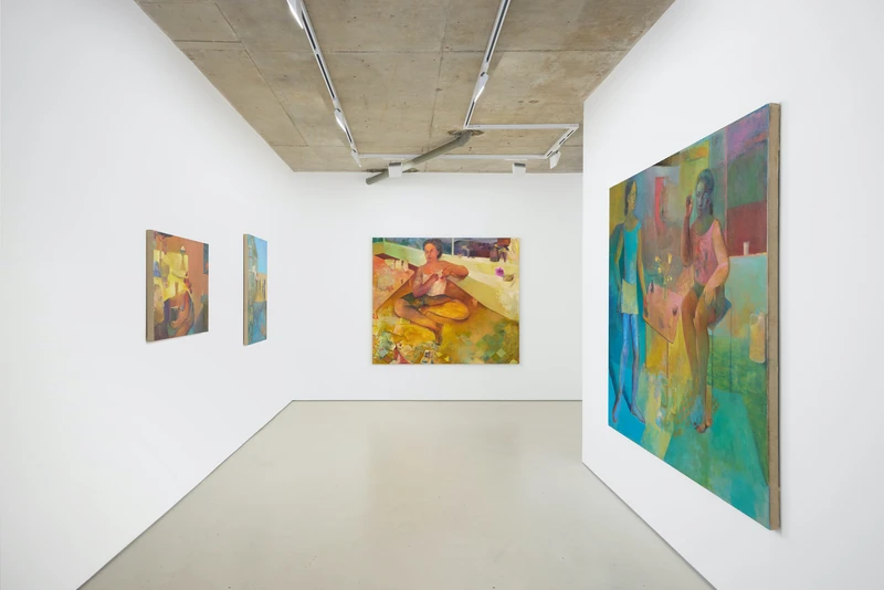 Artwork displayed on the walls of a gallery with a white interior.
