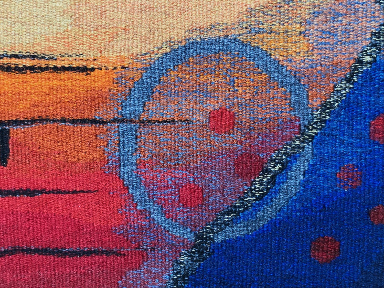 Abstract tapestry art featuring vibrant colors like orange, red, and blue, with circular and dotted patterns.