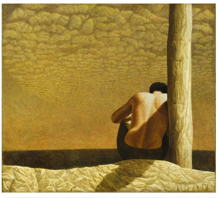 A man with his back turned sits against a large, textured pole, with a warm, clouded sky in the background.