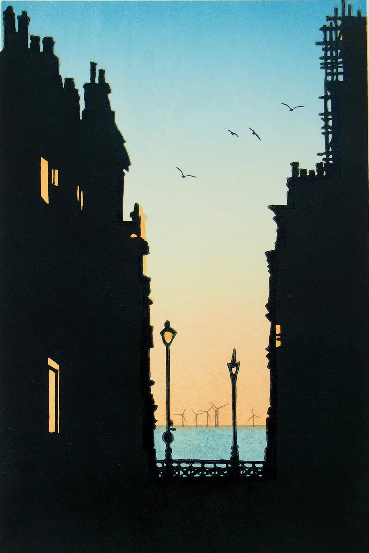 A silhouette of buildings with a view of the sea at sunset, featuring a few birds in the sky and wind turbines in the distance.