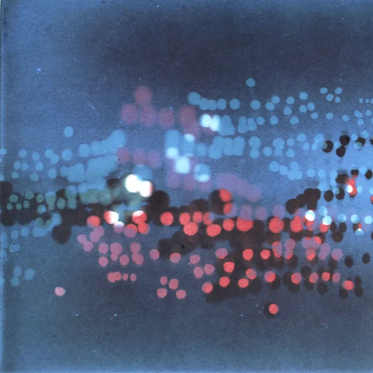 Abstract image with blurred blue, red, and white bokeh lights on a gradient background.