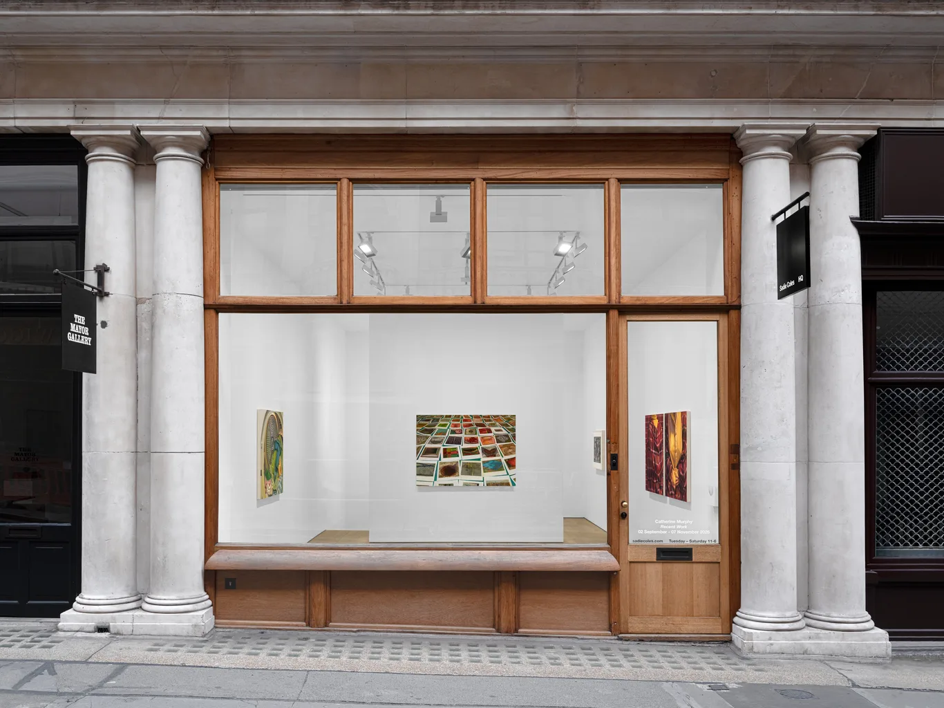 Classical gallery storefront with white columns, wood-framed windows, and colorful abstract paintings displayed in a quiet, elegant space. | 2026 Sadie Coles HQ