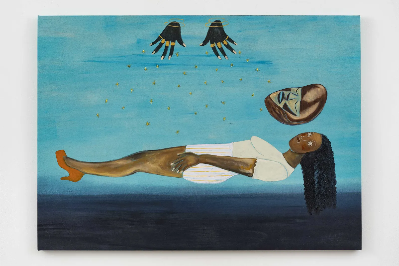 A dreamlike painting shows a dark-skinned woman floating horizontally above a shadowy sea, with black birds and a detached face overhead, creating a serene, surreal mood.